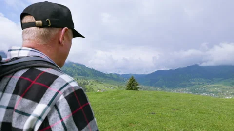 4K.Scene with  man backpacker in mountains looks in binoculars and go away Stockbeeldmateriaal 64019059