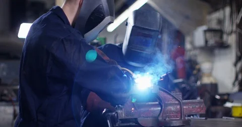 4KYoung apprentice in metalwork factory being trained by smiling female coworker Stock Footage 111644002