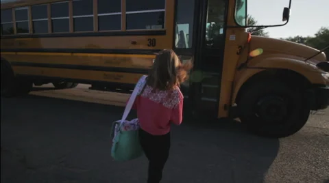 4th grade girl getting on school bus in the morning Stock Footage