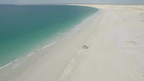 4WD Parked on Wide Sandy Beach along Curving Turquoise Shoreline at Djarindjin Stock Footage 341074247
