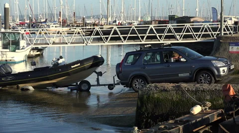 4x4 car pulls boat and trailer out of water at lymington, england Stock Footage 43243831
