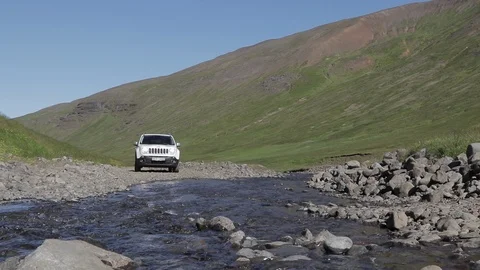4x4 Jeep drives through small river in green Iceland grassland (50 FPS) Stock Footage 104151480