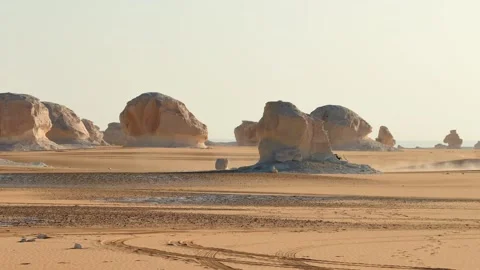 4x4 jeep driving fast across sandy desert plain among rock formations Vídeo Stock 340867549