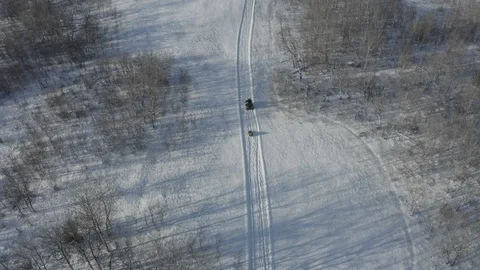 4x4 pulling a sled through the snow. Amazing drone shot zooming Stock Footage 124805364