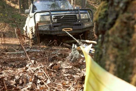 4x4 off-road car pulls itself out of the trap with a winch by snagging on a tree Stock Photos