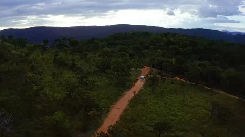 4x4 SUV drives along a winding dirt road through the Cerrado near Cavalcante Vídeos de archivo 345080810