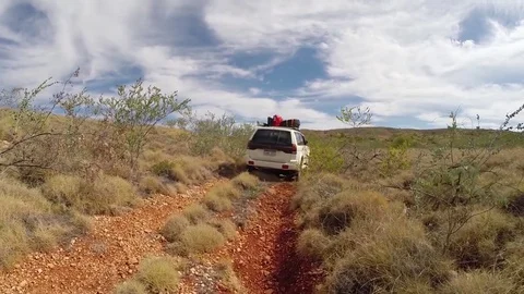 4x4 Vehicle driving over red earth through Australian outback bush Stock Footage 71134864