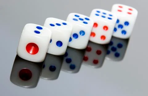 5 dices on the gray and reflexive table. Stock Photos