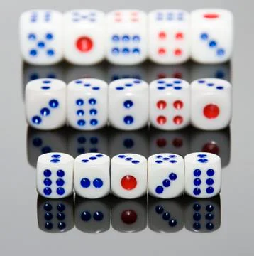 5 dices on the gray and reflexive table. Stock Photos