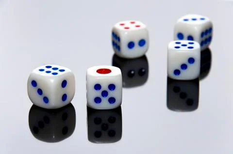 5 dices on the gray and reflexive table. Stock Photos