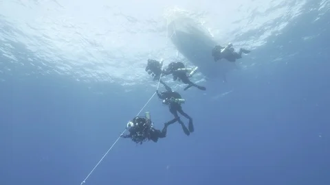 5 divers dive following the guide line tied to the boat,Mediterranean Sea, Italy Stock Footage 115417593