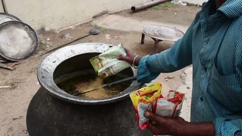 5-man-cooking-open-fire-large-pot-Hyderabad-India Stock Footage 93348151