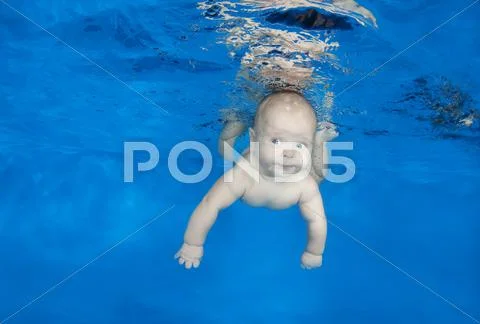 5 months infant boy learning to swim underwater in waterbaby class in the poo Stock Photos