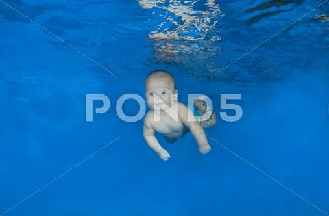 5 months infant boy learning to swim underwater in waterbaby class in the poo Stock Photos