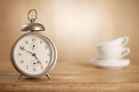 5 o'clock tea time, retro alarm and white tea cups on background Stock Photos