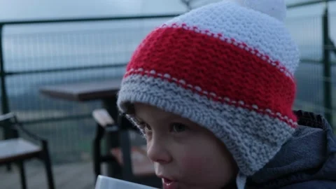 5-year-old boy drinking tea on the background of the mountains Stockbeeldmateriaal 165946024