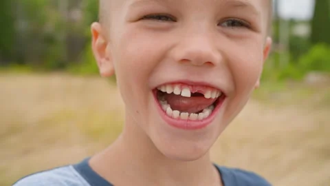 A 5-year-old boy smiles as he looks directly at the camera for a close-up. Stock Footage 276799757