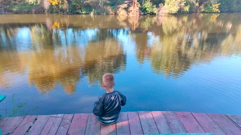 A 5-year-old boy throws stones into the sea. Entertainment during quarantine Stock Footage 163669563
