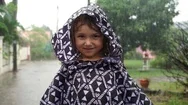 5 Year Old Girl In Raincoat Having Fun During A Heavy Tropical Rain. Slow Motion Stock Footage