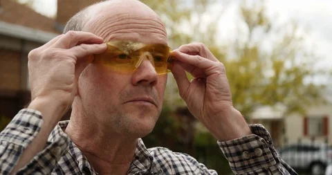 A 50-yea-old man puts on safety glasses. Stock Footage 129066601