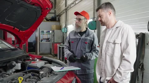 A 50 years old auto mechanic arguing with a client 库存影片 332720928