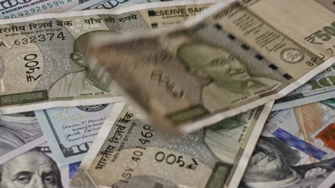 500 Indian rupee notes falling on one hundred US dollar banknotes Stock Footage 332839016