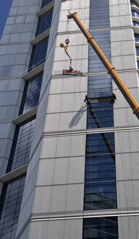 500 Ton Crane Lifting Large Glass Pane for High Altitude Installation Vertical Stock Footage 332902599