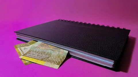 A 5000 Sri Lankan rupee note inside a book on a pink background Stock Photos