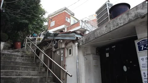 5113 Back View of a Woman Walking Up a Narrow Hillside Alley in South Korea Stock Footage 338224747
