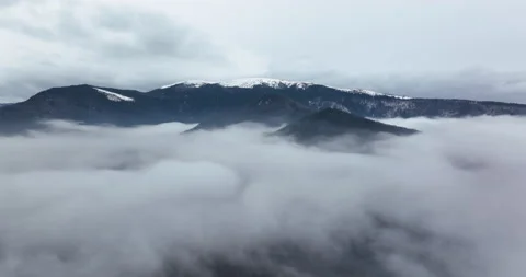 A 5.1k drone video flying through a layer of fog with a moutain view on the back Stock Footage 174402855