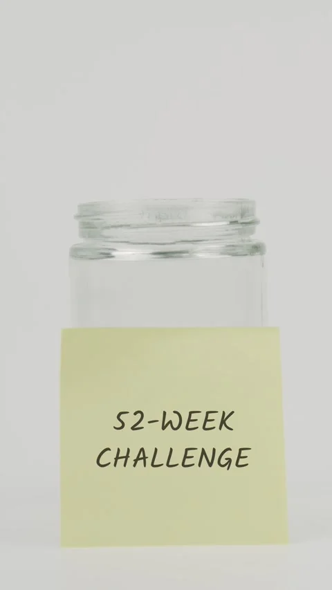 52-week challenge text or word on yellow sticky note attached to glass jar Stock Footage 311675058