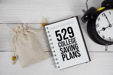 529 College Saving Plans text on notepad with money bag and alarm clock on .. Stock Photos