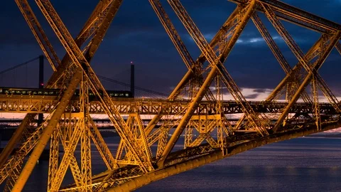 5.2K Aerial train crossing Forth Rail Bridge at night Stock Footage
