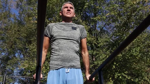 54-Year-Old Fit Man Doing Parallel Bar Dips - Bottom View Video stock 296837622
