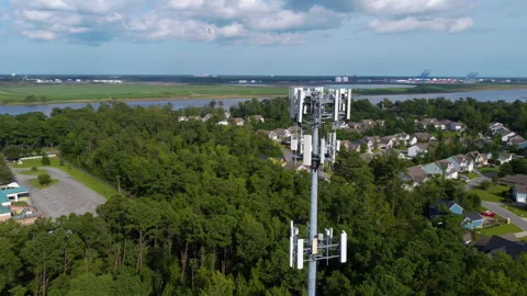 5G Cell Phone Tower in front of Neighborhood with a River and Shipping Port in B Stock Footage 247805770