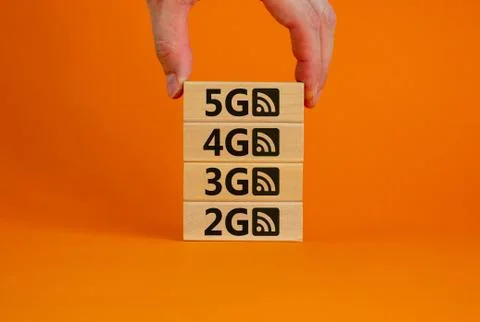 5G network evolution concept. Hand holding a wooden block with text and symbo Stock Photos