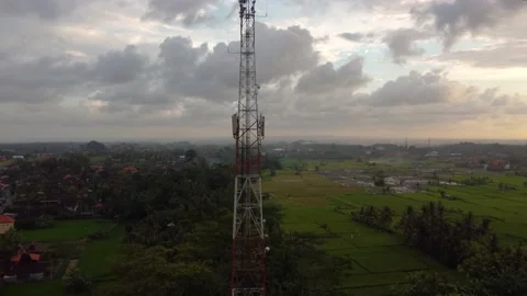 5g telecom tower antenna at sunset in country side plowed green field Stock Footage 143368067