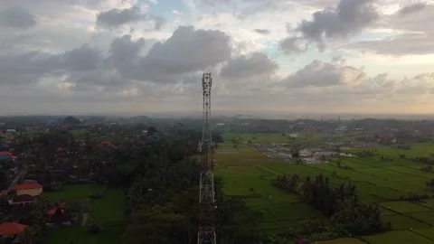 5g telecom tower antenna at sunset in country side plowed green field Stock Footage 143368134