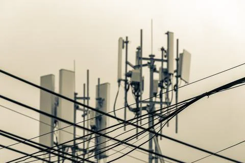 5G telecom tower mounted on rooftop building blue sky urban communication s.. Stock Photos