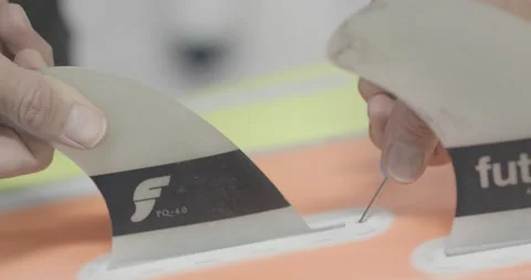 5K Close up of professional surfer adjusting and screwing parts on surfboard Stock Footage 160778813
