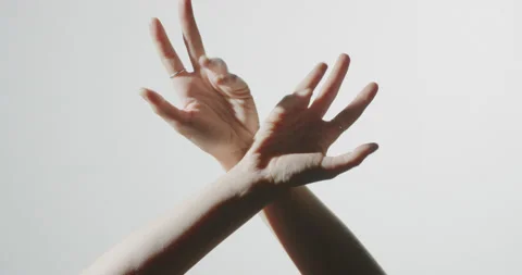 5K. WOMANS HANDS MAKING ABSTRACT SHAPES IN FRONT OF A WHITE WALL Stock Footage 136570848
