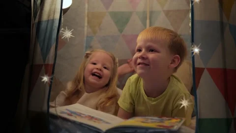 A 5s year old boy reads a book to his little sister before going to bed Stock Footage 237398659
