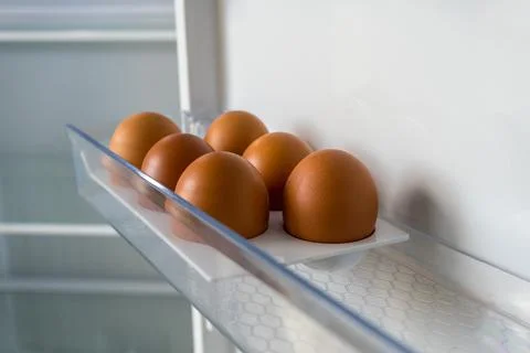 6 brown chicken eggs in an empty colloquially fridge. half dozen eggs Stock Photos