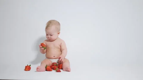 6 month old baby eats red strawberries. concept of healthy food for children, Stock Footage 242780919