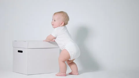 6-month-old Baby learns to stand on his feet and balance. Studio video on a l Stock-Footage 242768472