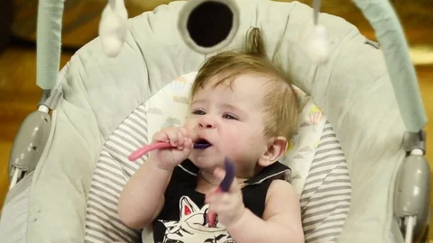 6 month old boy holding a spoon Stock Footage 114968070