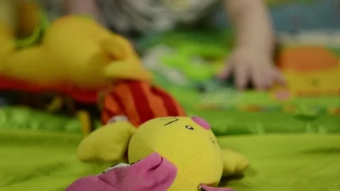 A 6 month old boy with long blond hair, plays with a mobile Stock Footage 114967834