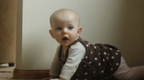 6 month old plays on the ground in a polka dot jumper Vídeos de archivo 35800142