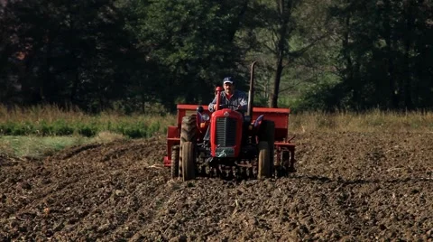 6. Sowing. Tractor preparing land. Seeder for sowing in a field. Telephoto lens. Stock Footage 43159234