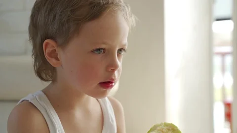 6 year old boy eating green apple pulled out primary tooth Stock Footage 107934724